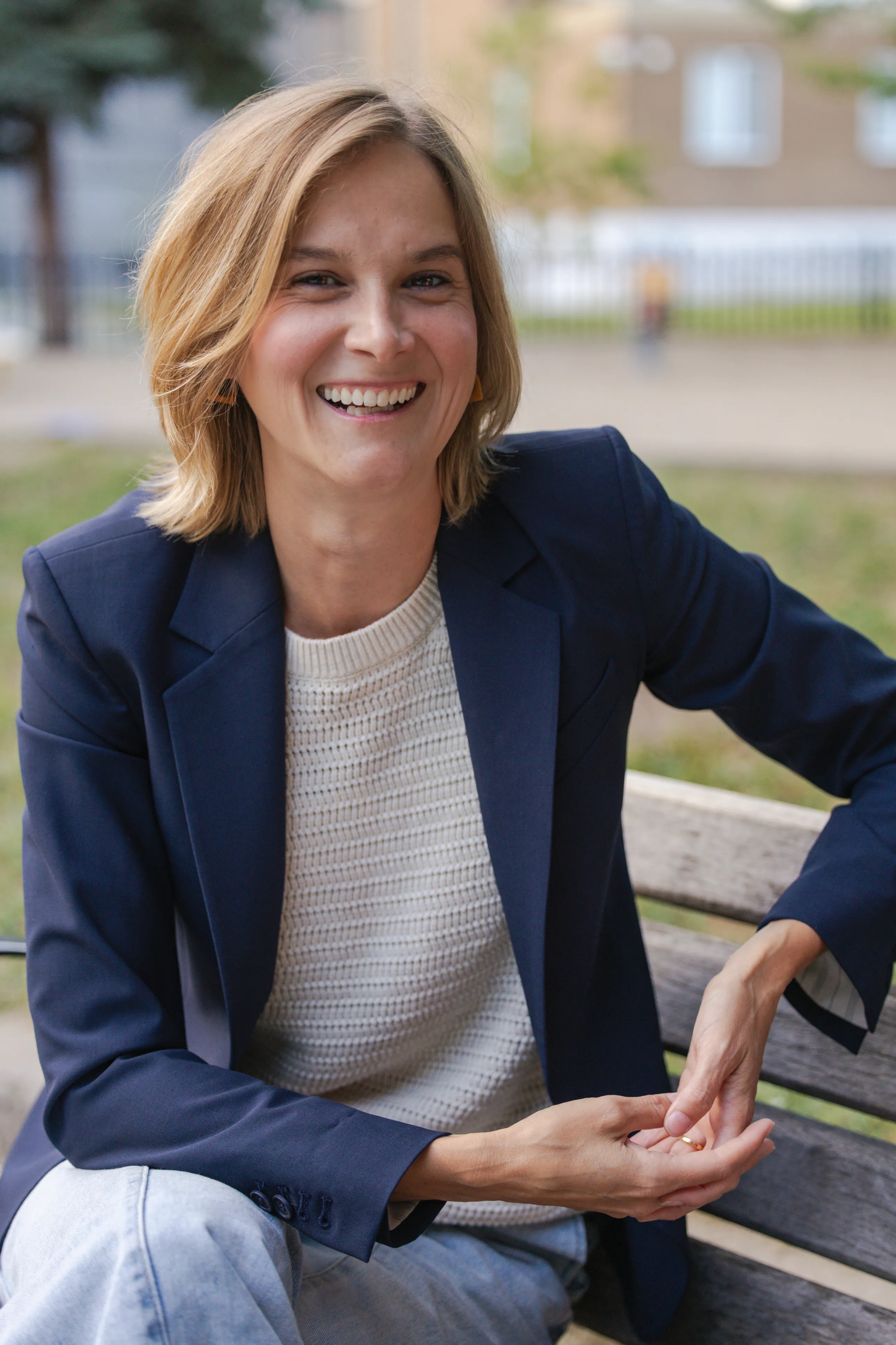 Laura Dean laughing on a park bench in Toronto, warm evening light